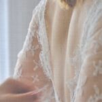 Main de wedding planner en Provence qui ajuste une robe de mariée