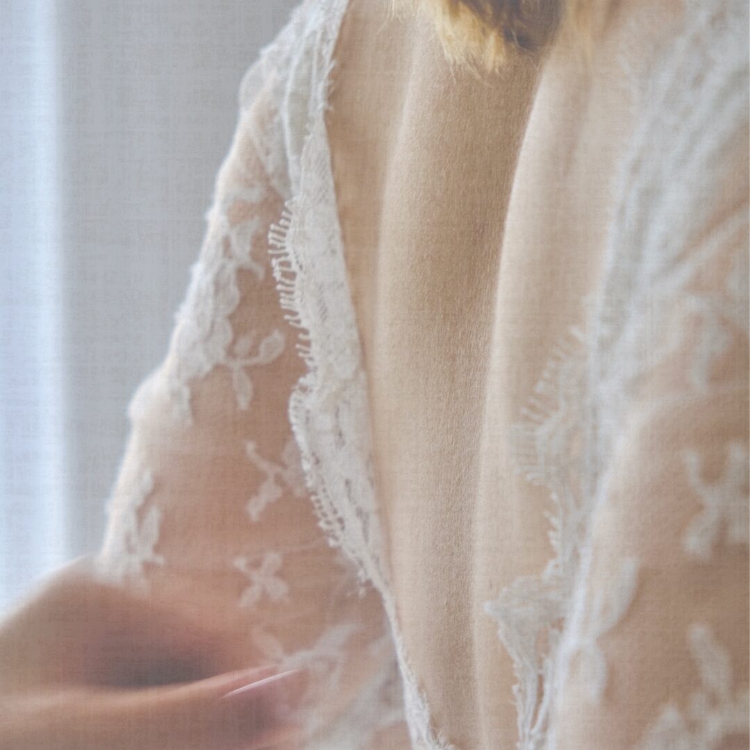Main de wedding planner en Provence qui ajuste une robe de mariée